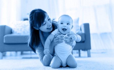 Woman playing with a baby, blue wash over image