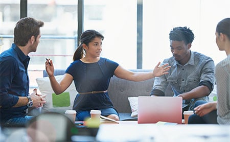 Four colleagues engaged in a discussion.