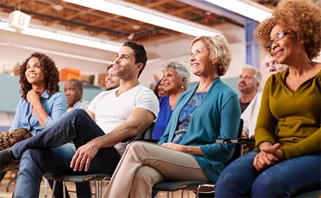 A diverse audience listens to a speaker