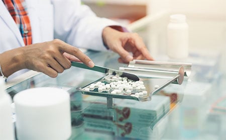 A pharmacist counting out pills.